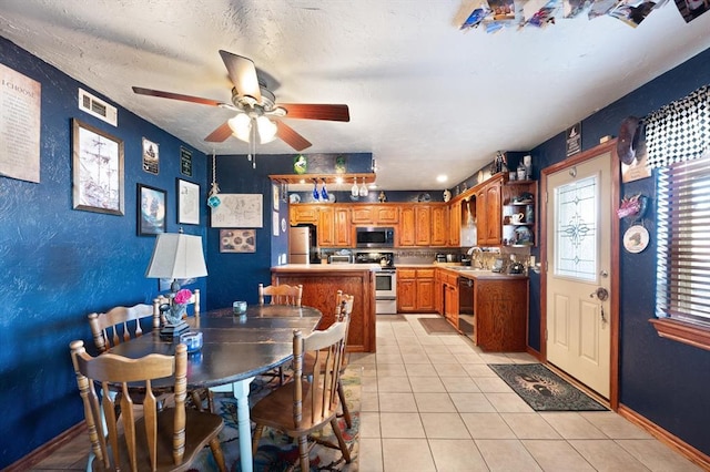 dining room featuring ceiling fan, light tile patterned flooring, sink, and a textured ceiling