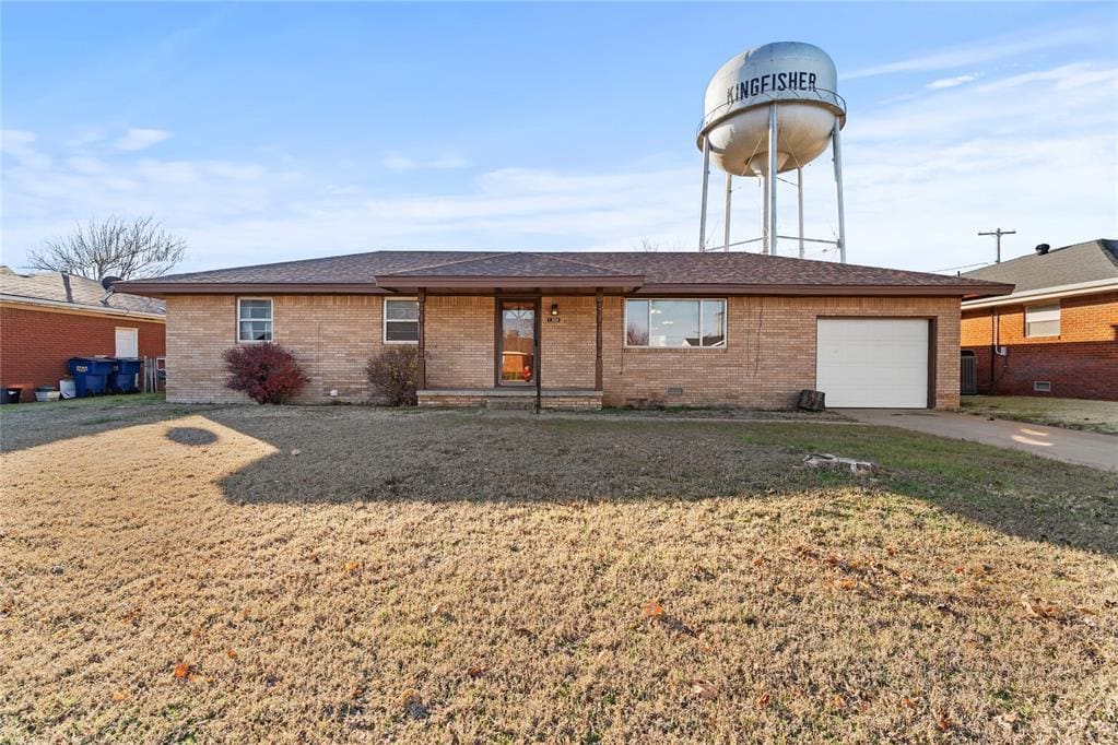 ranch-style home with a garage and a front lawn