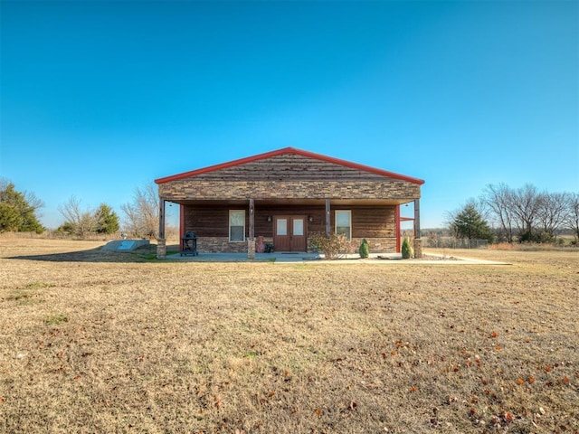 back of house with french doors and a yard