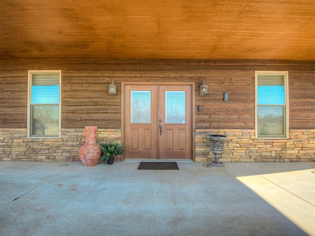 view of exterior entry featuring covered porch and french doors