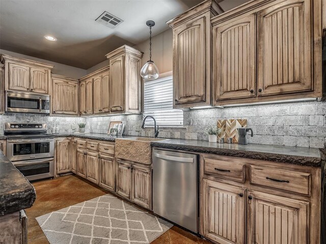 kitchen with a sink, visible vents, stainless steel appliances, and backsplash