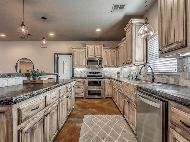 kitchen with cream cabinets, a sink, visible vents, appliances with stainless steel finishes, and tasteful backsplash