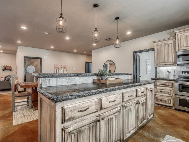 kitchen with recessed lighting, stainless steel appliances, visible vents, cream cabinetry, and tasteful backsplash