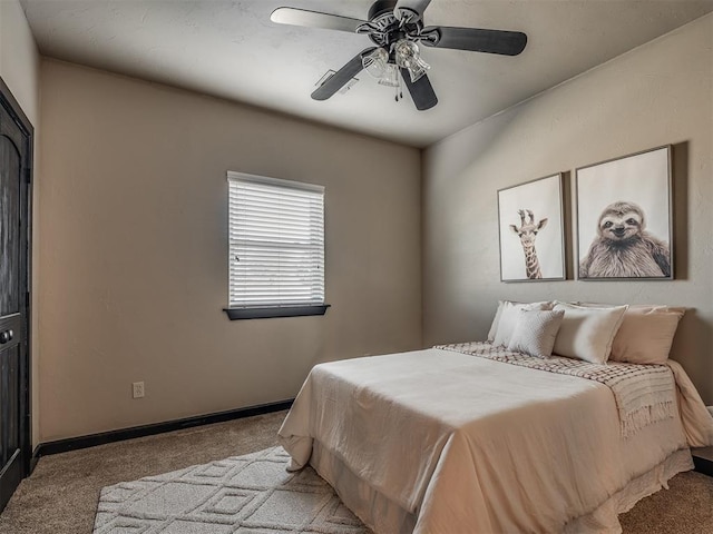 bedroom with a ceiling fan, baseboards, and carpet flooring