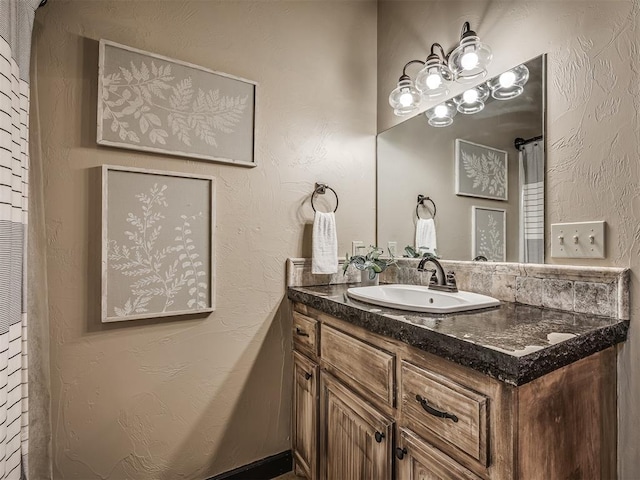 bathroom featuring a textured wall and vanity