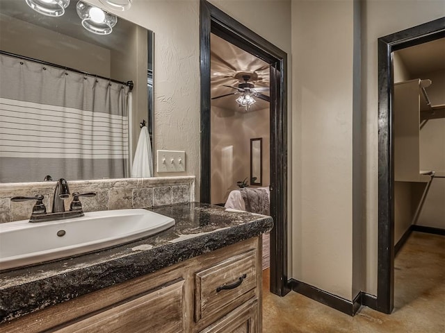 bathroom featuring baseboards, a textured wall, ceiling fan, vanity, and concrete floors