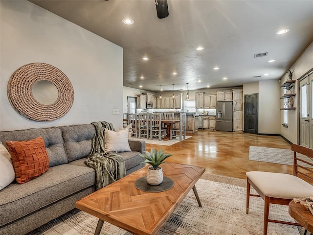 living room with recessed lighting, visible vents, finished concrete flooring, and baseboards