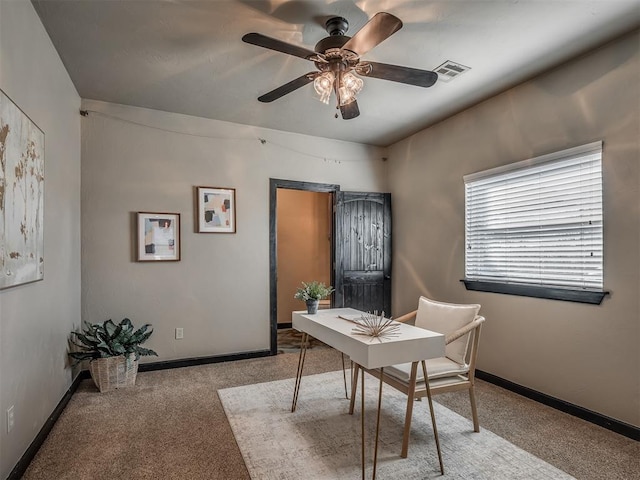 carpeted home office with a ceiling fan, visible vents, and baseboards