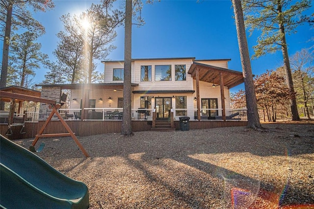 back of property featuring a playground