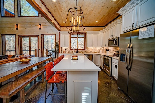 kitchen with appliances with stainless steel finishes, wooden ceiling, white cabinets, a center island, and hanging light fixtures