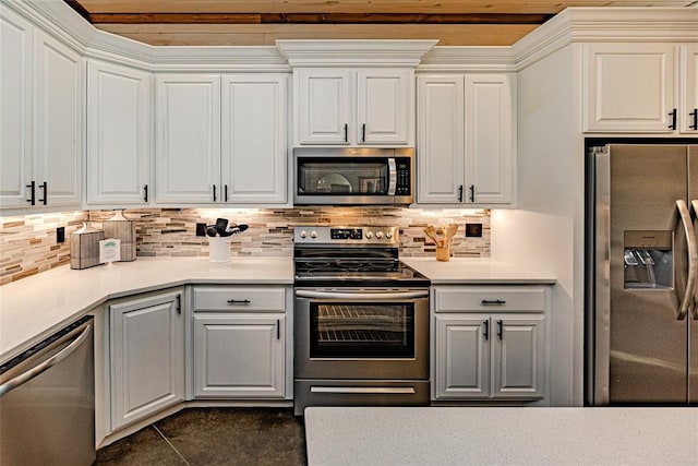 kitchen featuring white cabinets, appliances with stainless steel finishes, backsplash, and dark tile patterned floors