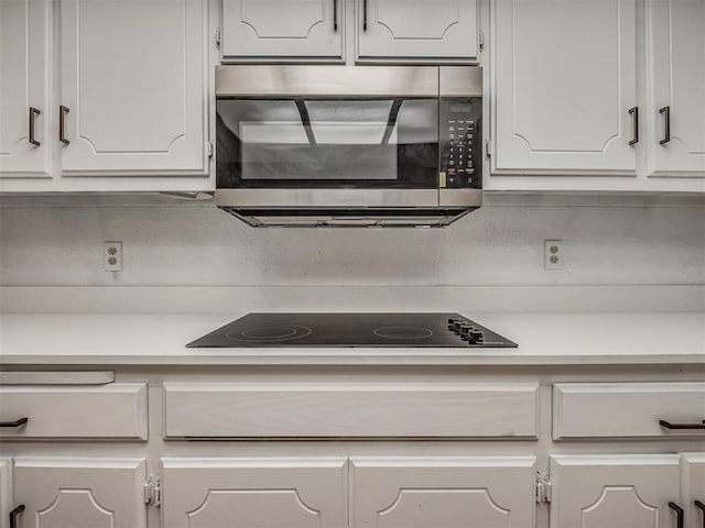 kitchen with white cabinets and black electric stovetop