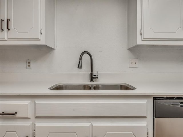 kitchen featuring white cabinets, dishwasher, and sink