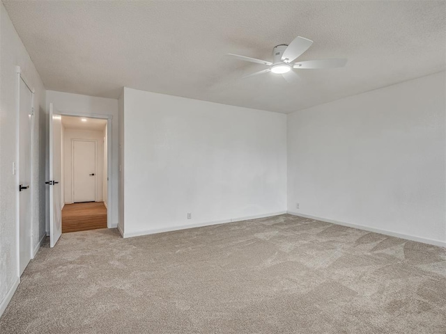 carpeted spare room with a textured ceiling and ceiling fan