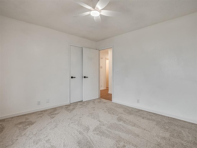 unfurnished bedroom featuring ceiling fan and light carpet