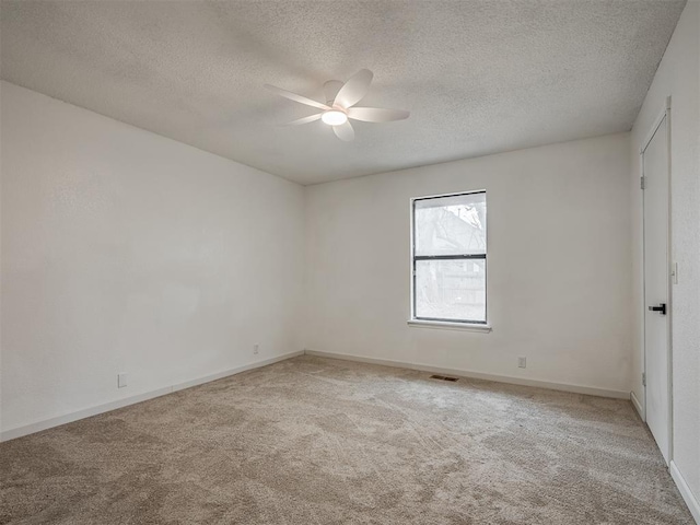 carpeted empty room with ceiling fan and a textured ceiling