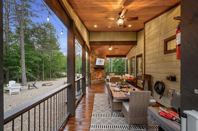 sunroom / solarium featuring ceiling fan and wood ceiling