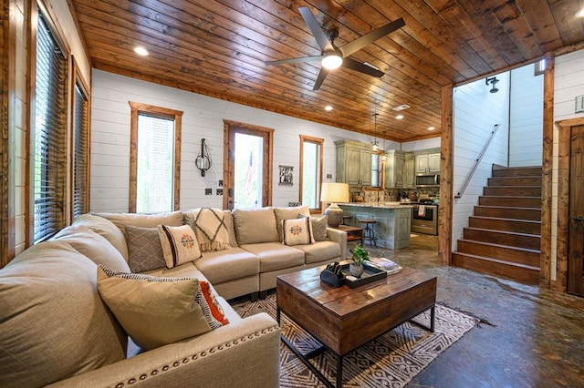 living room with wood ceiling, ceiling fan, and wood walls