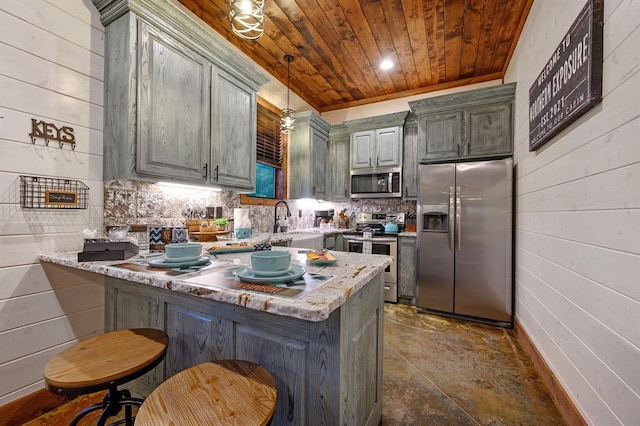 kitchen featuring kitchen peninsula, wood walls, pendant lighting, wood ceiling, and appliances with stainless steel finishes