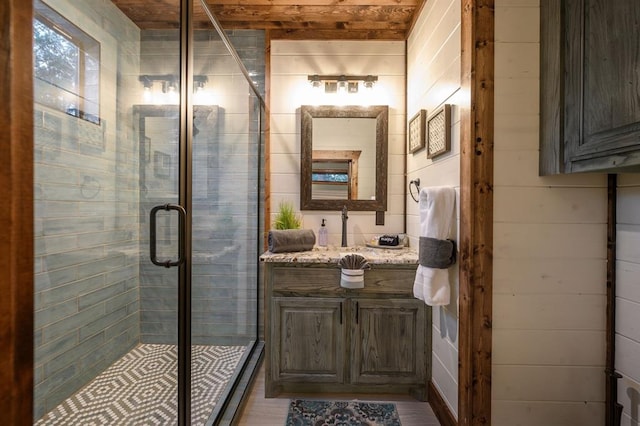 bathroom with wooden walls, vanity, wood ceiling, and a shower with shower door