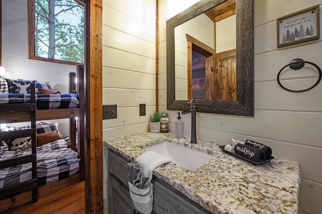 bathroom featuring wood walls and vanity