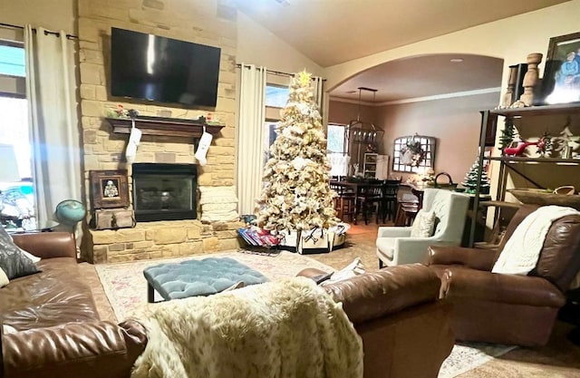 living room with ornamental molding, a fireplace, and vaulted ceiling