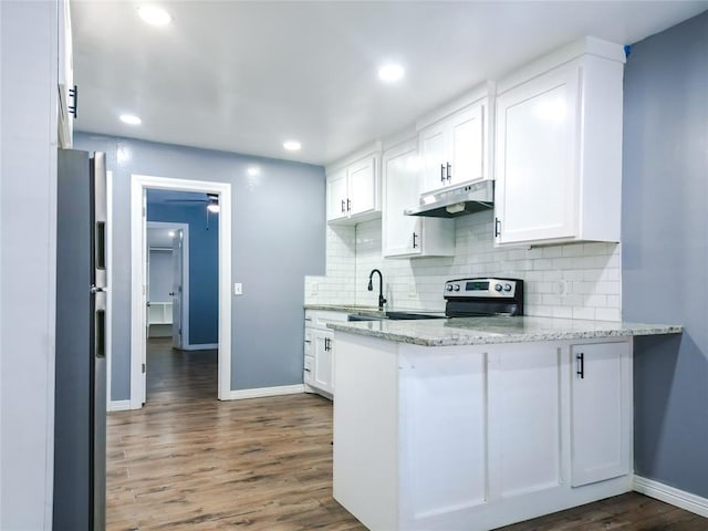 kitchen featuring stainless steel appliances, white cabinetry, light stone countertops, and backsplash