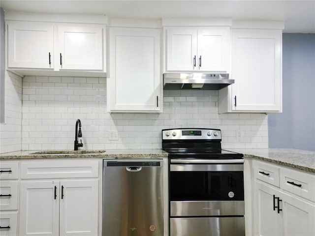 kitchen with stainless steel appliances, white cabinets, and light stone counters