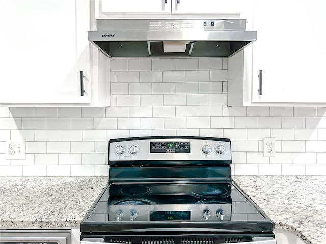 kitchen with decorative backsplash, white cabinets, light stone counters, and stainless steel electric range