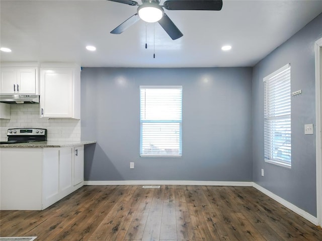 kitchen featuring tasteful backsplash, electric range, dark hardwood / wood-style floors, light stone countertops, and white cabinets