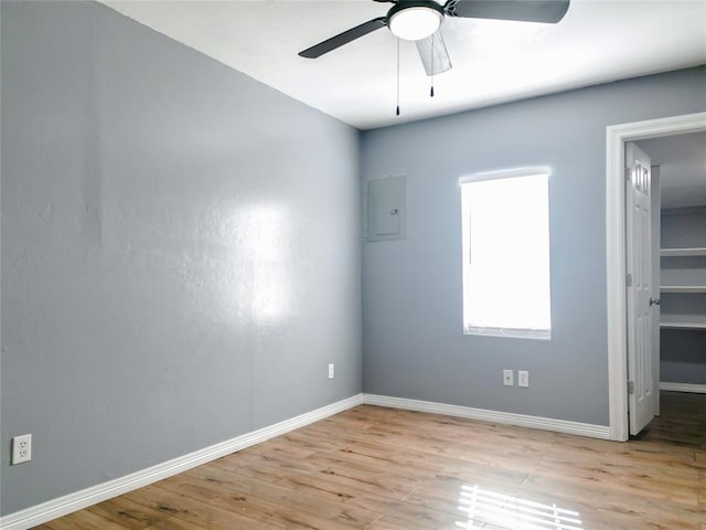 unfurnished room featuring ceiling fan, electric panel, and light wood-type flooring