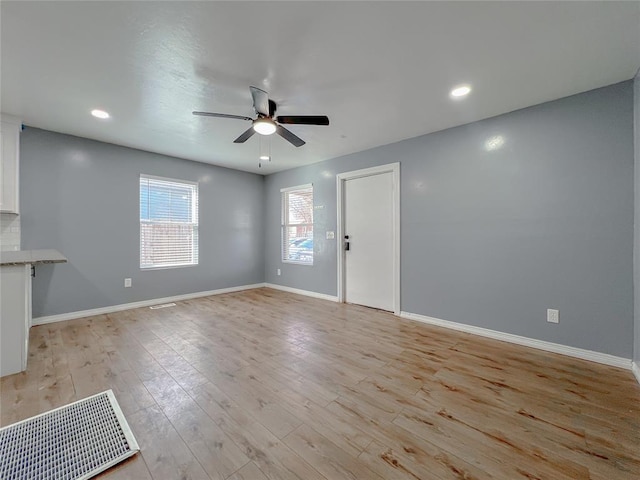 unfurnished living room with ceiling fan and light wood-type flooring