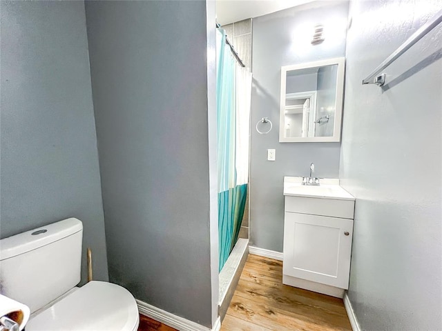 bathroom with a shower with curtain, wood-type flooring, vanity, and toilet