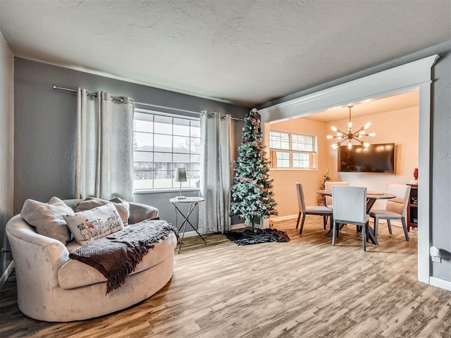 living room featuring wood-type flooring, a wealth of natural light, and a chandelier