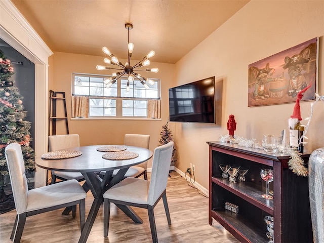 dining room with light hardwood / wood-style floors and an inviting chandelier