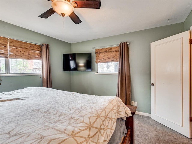 carpeted bedroom with multiple windows and ceiling fan