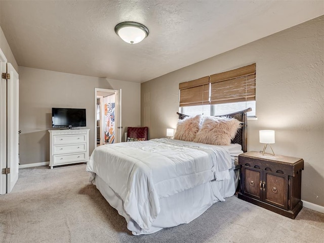 bedroom featuring light carpet and a textured ceiling