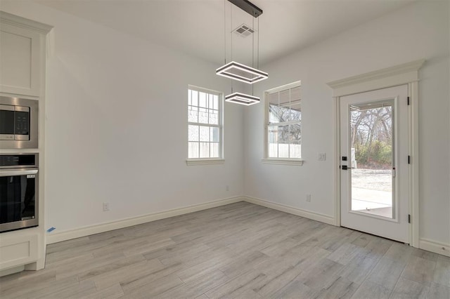 unfurnished dining area with a healthy amount of sunlight and light wood-type flooring