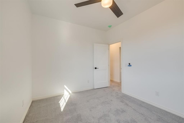 empty room featuring ceiling fan and light carpet