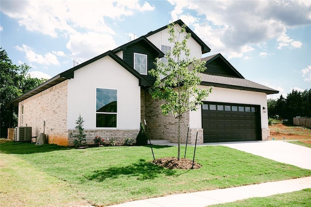 view of front of property featuring a garage, central air condition unit, and a front lawn