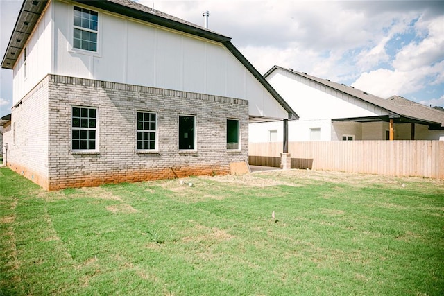 rear view of property featuring a lawn