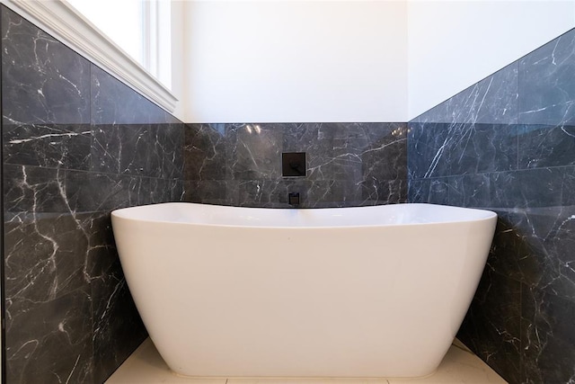 bathroom featuring a bathtub and tile walls