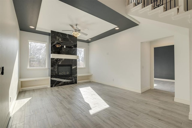 unfurnished living room featuring a fireplace and ceiling fan