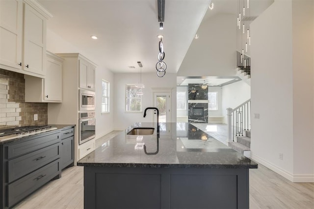 kitchen featuring ceiling fan, sink, a spacious island, and appliances with stainless steel finishes