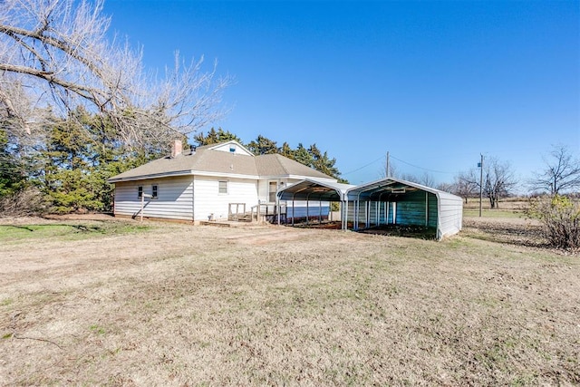 back of house with a carport and a lawn