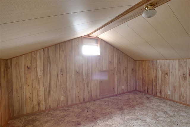 bonus room with vaulted ceiling with beams, wood walls, and carpet floors