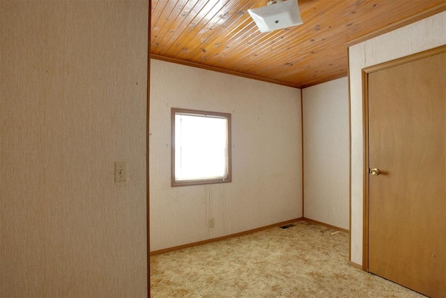 spare room featuring light carpet, crown molding, and wooden ceiling