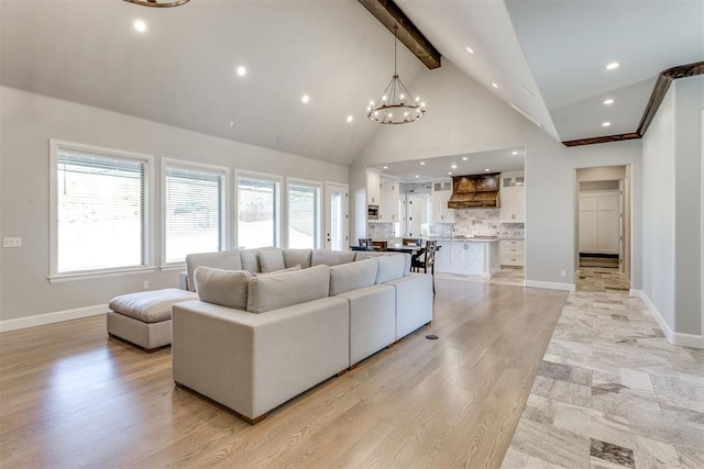 living room with vaulted ceiling with beams, light hardwood / wood-style flooring, and a notable chandelier