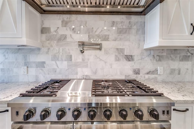 kitchen featuring decorative backsplash, light stone countertops, white cabinetry, and stainless steel gas cooktop