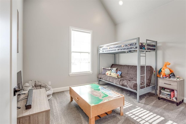 carpeted bedroom with high vaulted ceiling